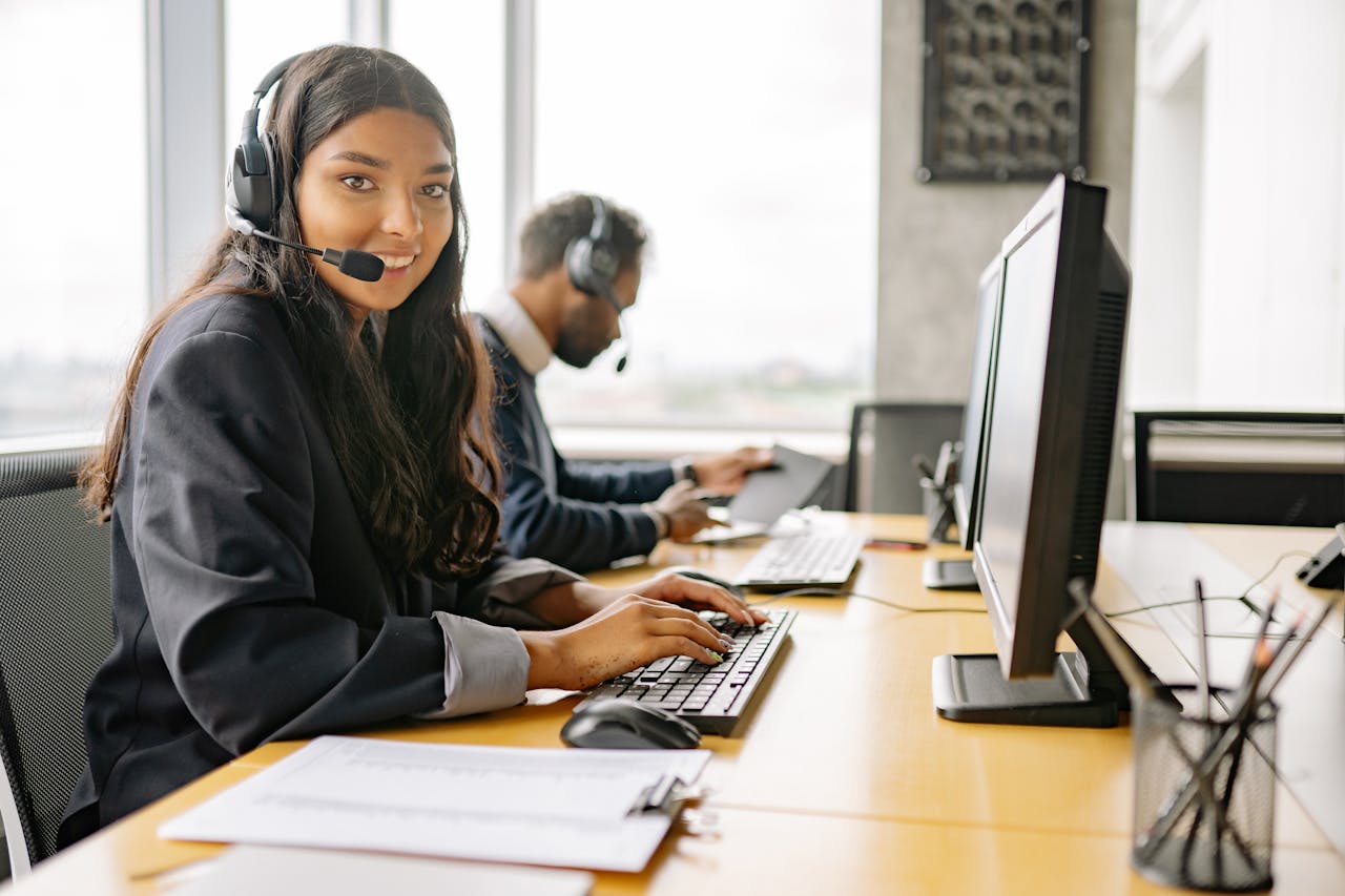 about-img Smiling call center agents in an office providing customer support on computers.